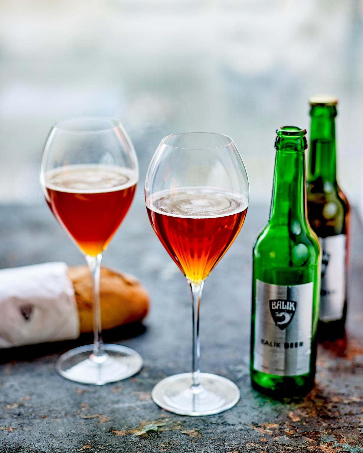 BALIK Beer in zwei Weingläsern, daneben Flaschen und Brot