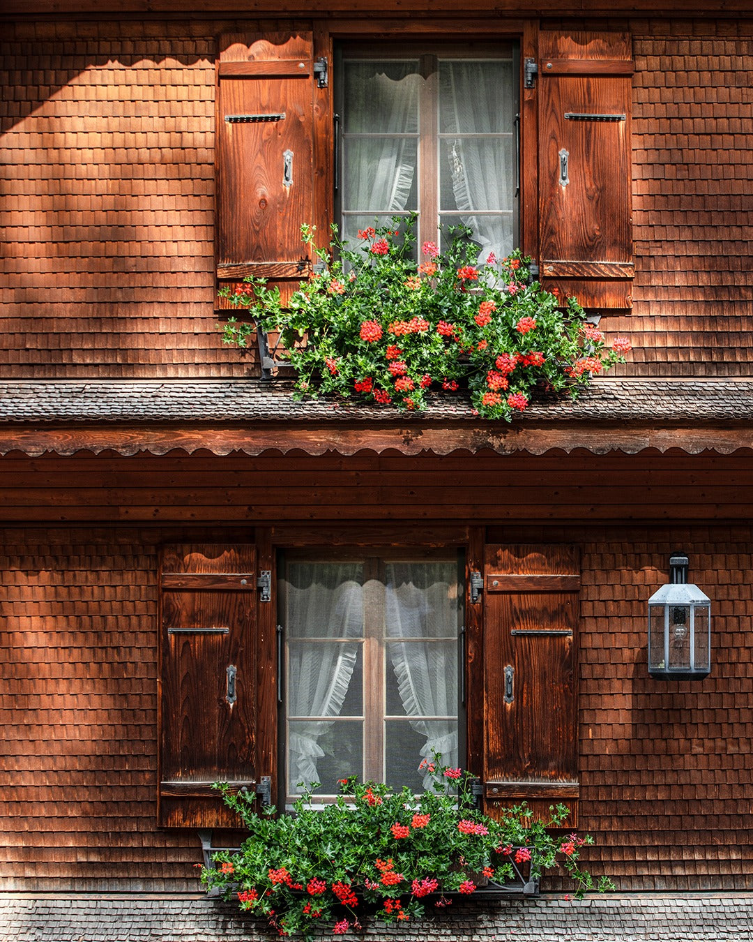 Hausfront der BALIK Farm mit Fensterläden und Blumen