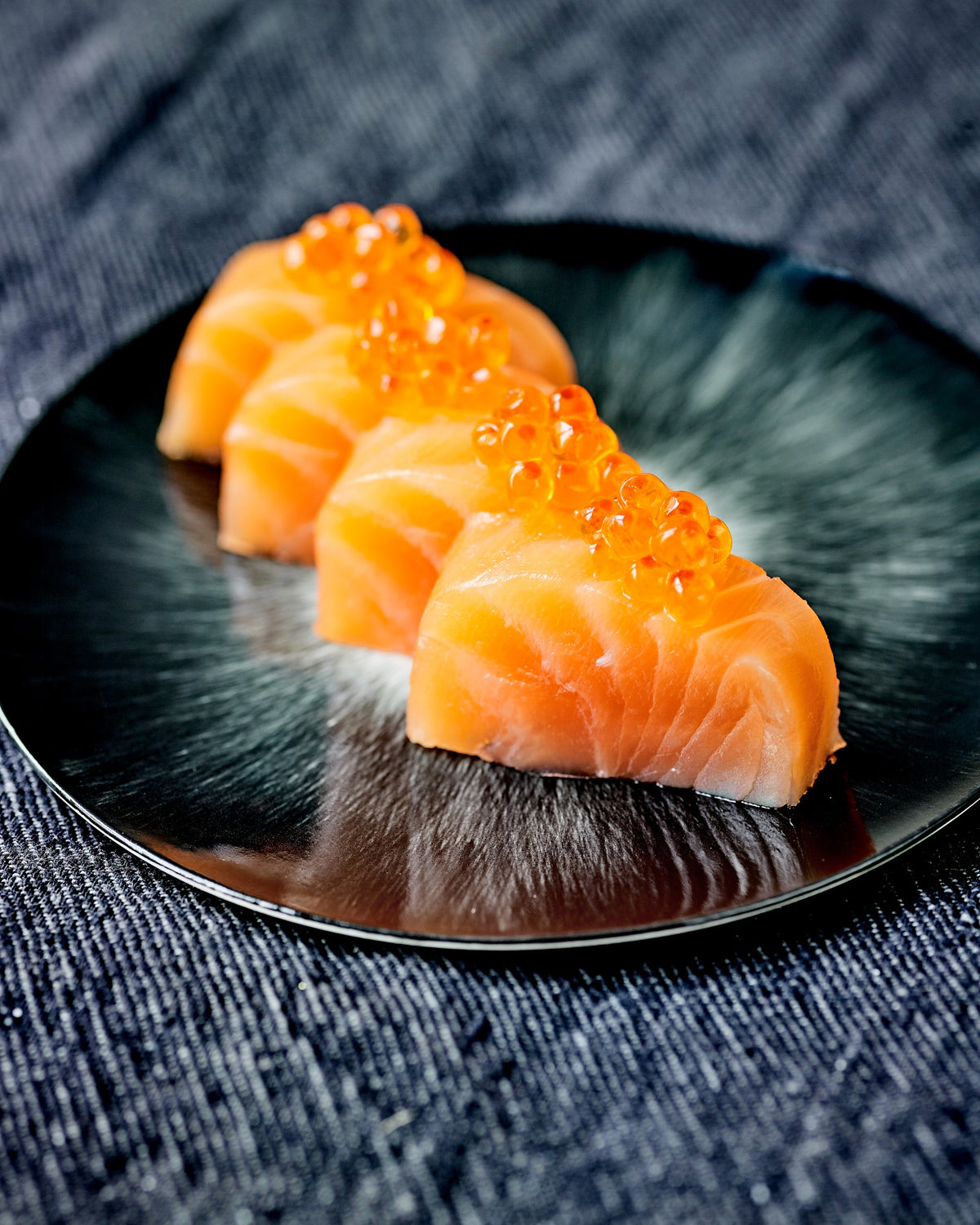 BALIK Lachsmedaillons mit Salmon Eggs auf dunklem Teller