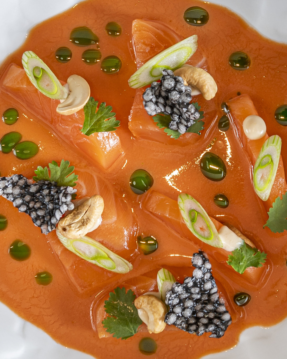 BALIK Sashimi Style angerichtet in Sauce mit Kaviar, Frühlingszwiebeln und Kräuteröl