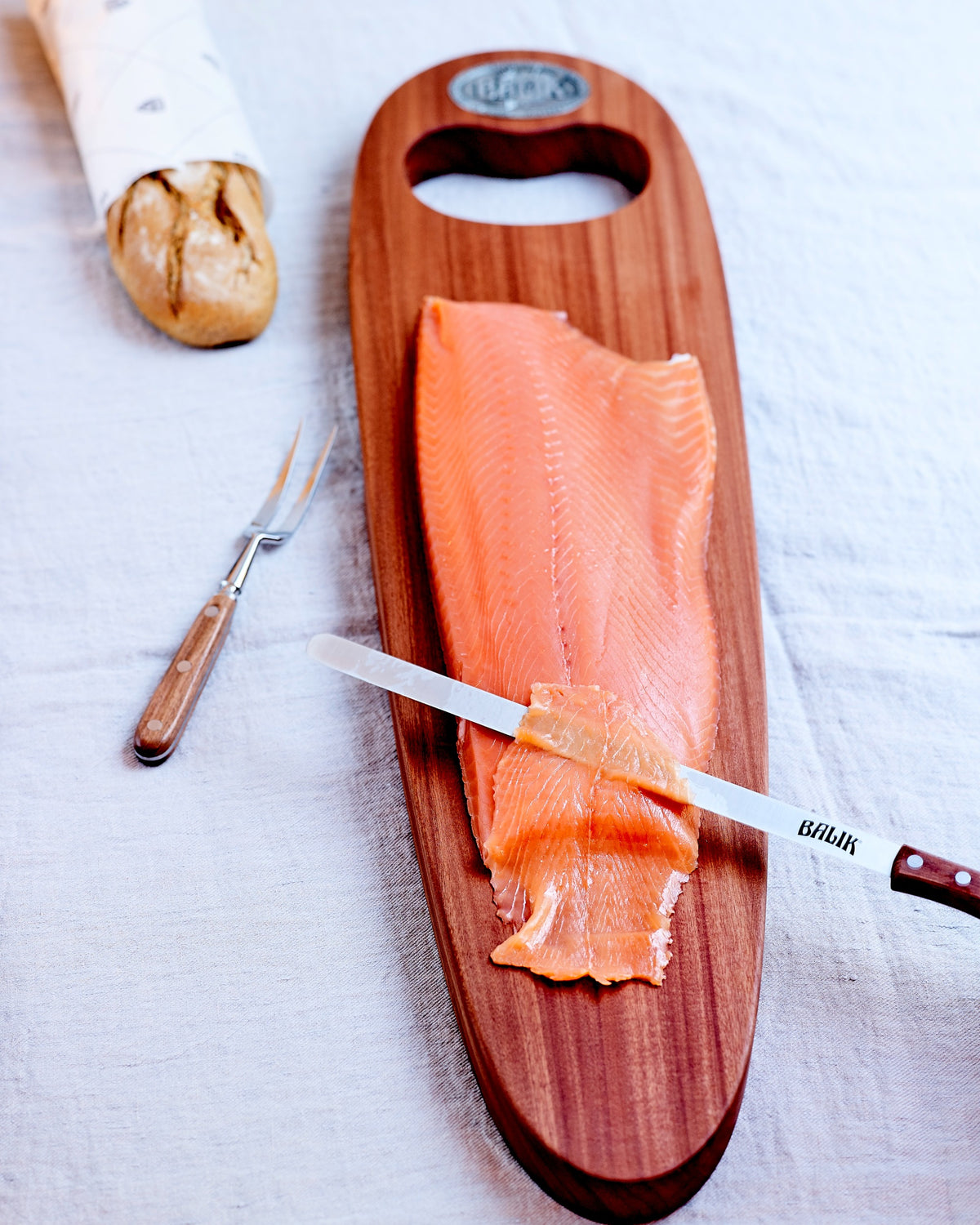 BALIK Lachsseite auf dem Holzbrett, tranchiert, mit Brot