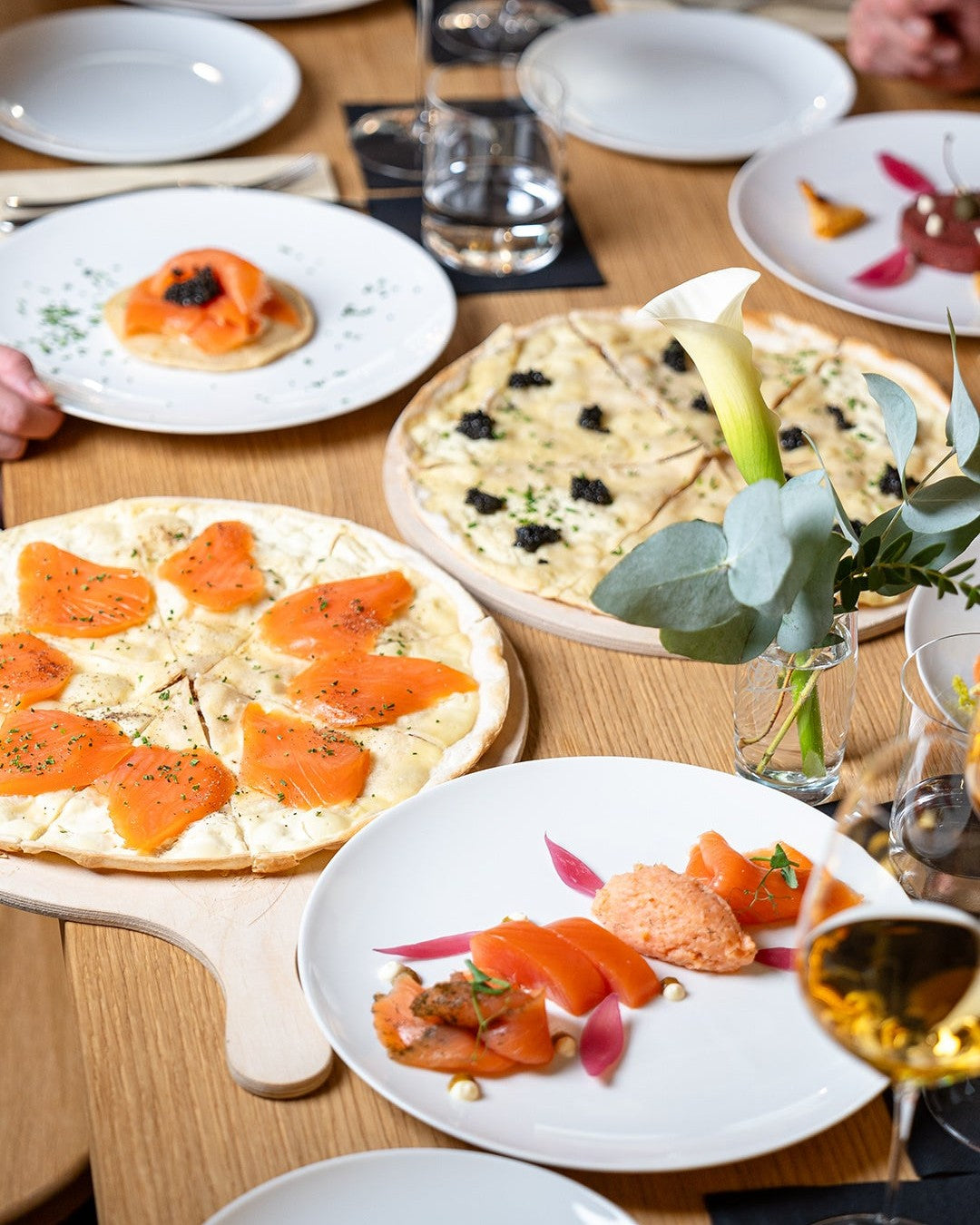 Gedeckter Tisch mit BALIK Lachs, Flammkuchen und Kaviar, von oben