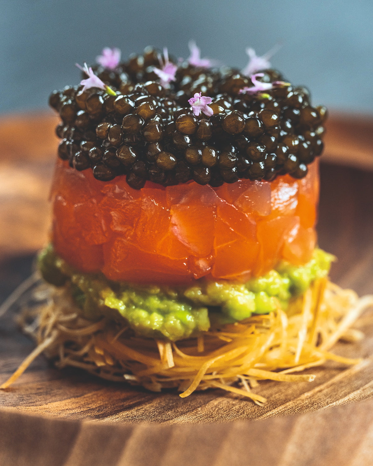 Türmchen aus BALIK Tartar Nature mit Kaviar und Avocado auf Kartoffelstroh